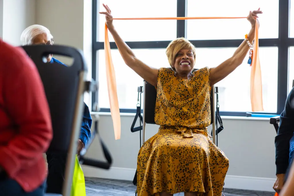 Clarendale Six Corners resident in seated armband workout class 