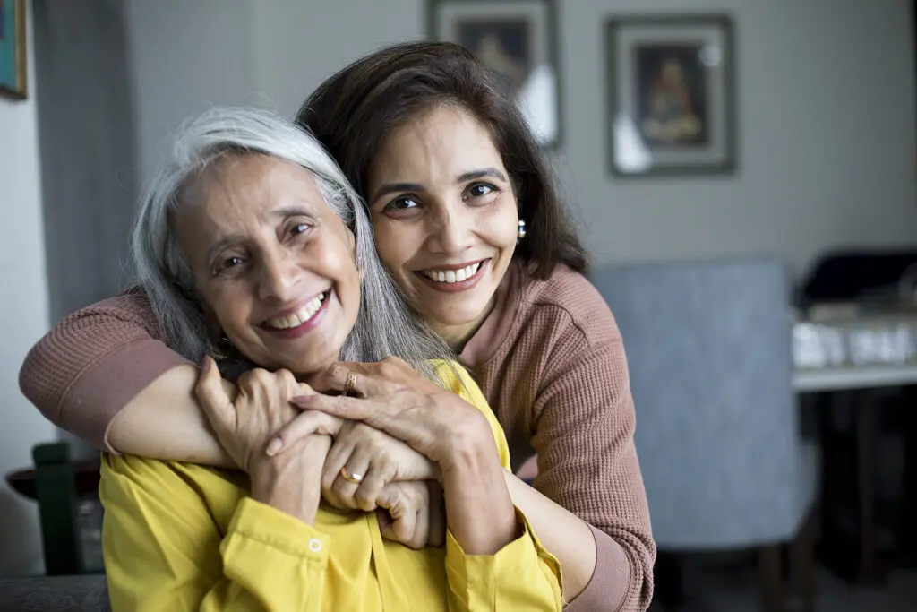 Senior woman and daughter smiling after reading 20 things not to say to someone with dementia.
