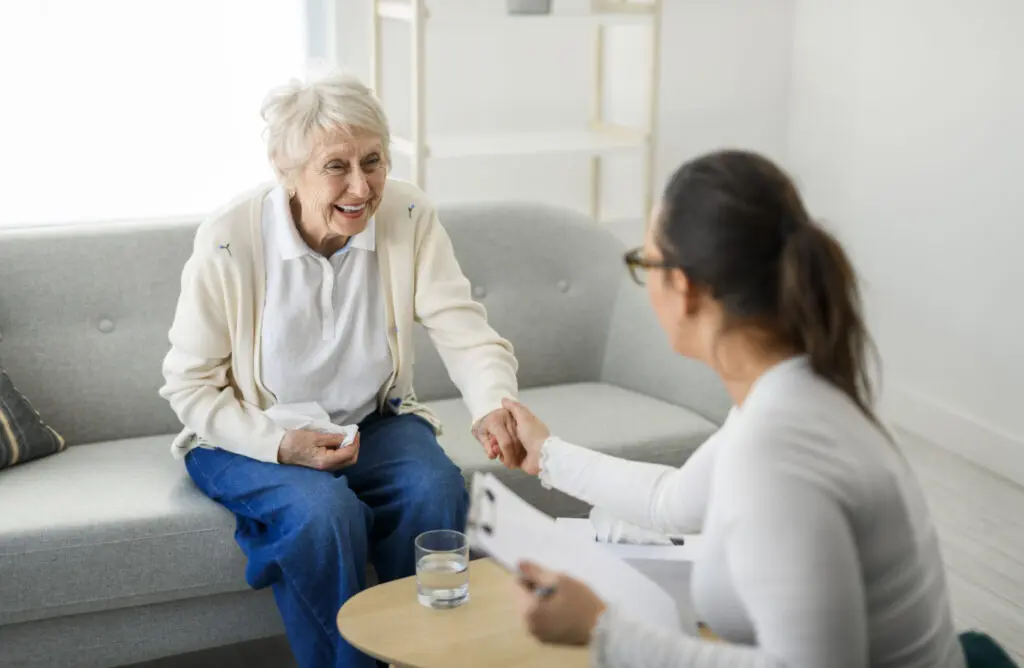 Woman reaching out and speaking with senior woman after reading 20 things not to say to someone with dementia.