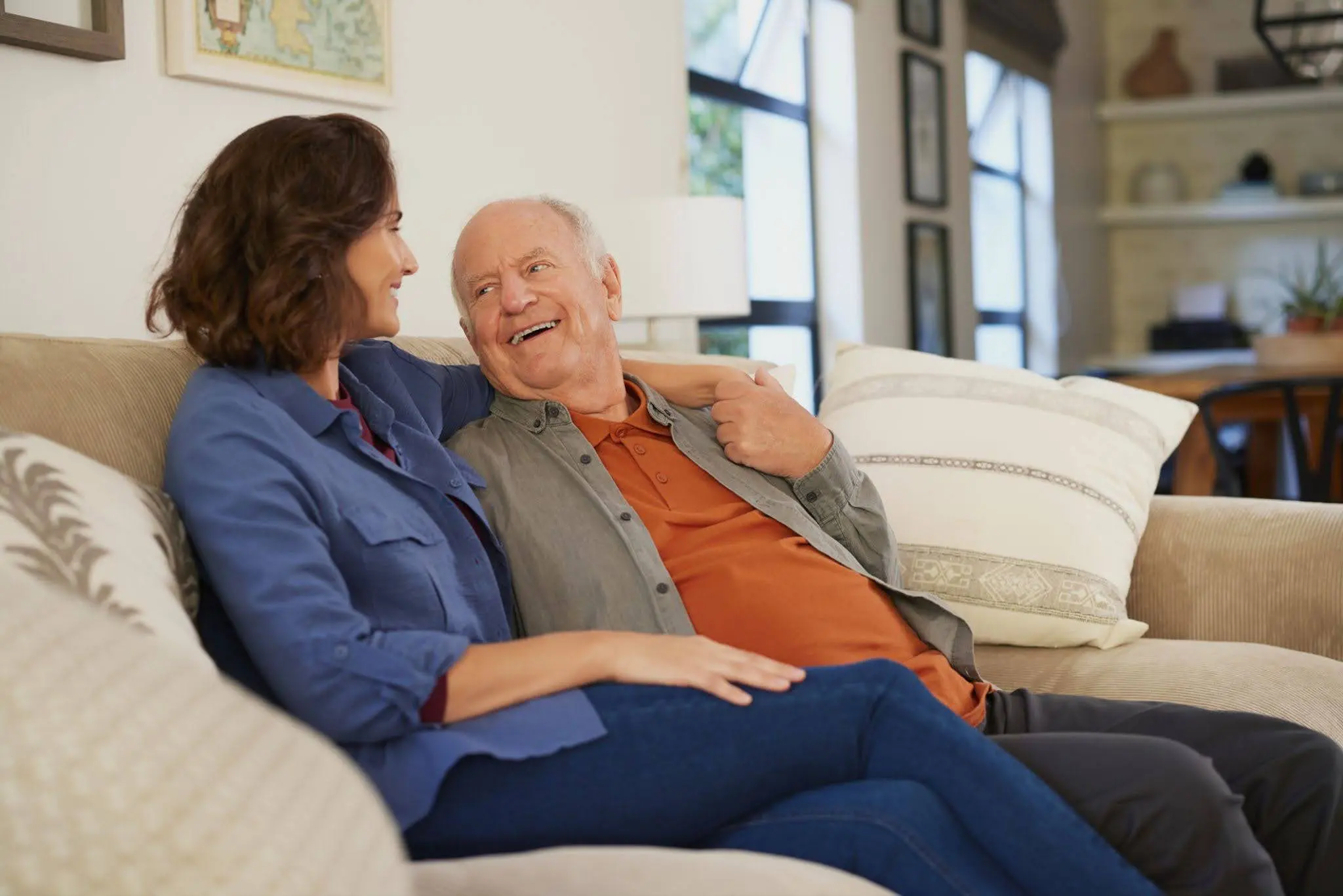 An adult daughter hugging and talking with her elderly dad about choosing senior living for a parent in Chicago, IL, like Clarendale Six Corners.