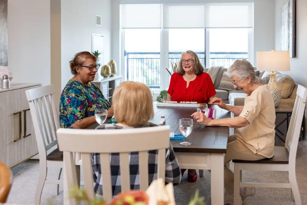 a group of senior women sitting at the dining room table playing a game together