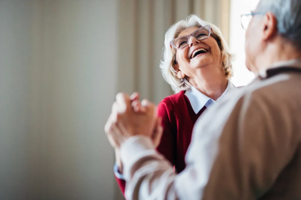 An elderly couple dancing in their home at Clarendale Six Corners while exploring hobbies as a couple.