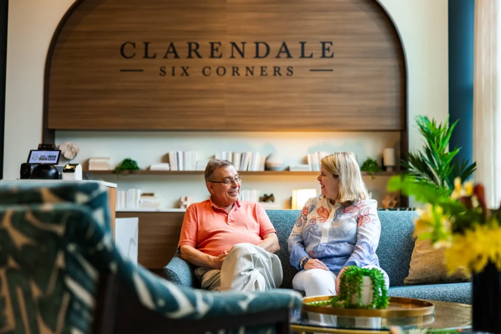 Two senior in the lobby of Clarendale Six Corners talking about moving to independent living in Chicago.